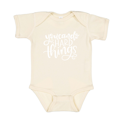 You Can Do Hard Things design on a Natural infant onesie, front view.