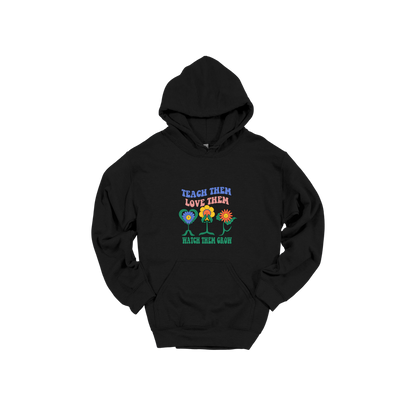 Teach Them Love Them teacher design on Black adult Hoodie, front view.