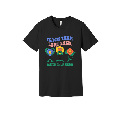 Teach Them Love Them teacher design on Black adult T-Shirt, front view.