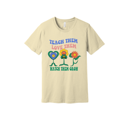 Teach Them Love Them teacher design on Natural adult T-Shirt, front view.