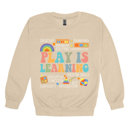 Play Is Learning design shown on Sand adult Gildan crewneck sweatshirt.